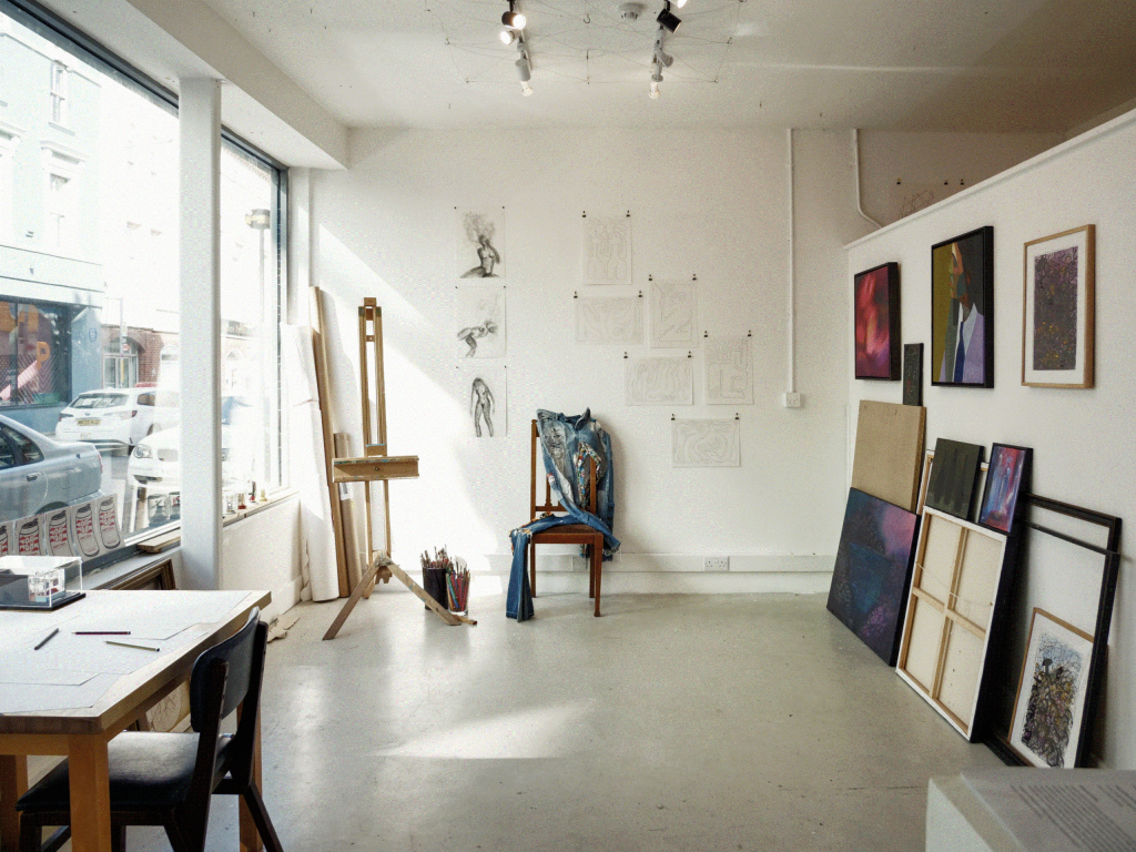 Drawings, paintings, an easel and a installation in a quiet, sunlit gallery